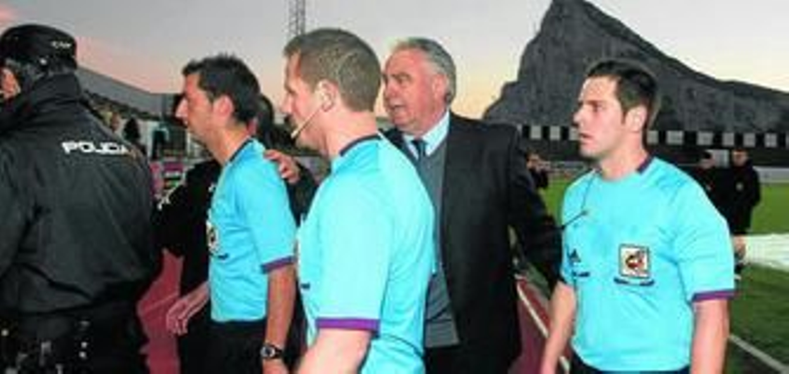 Artacho Cobo (primero por la derecha) abandona el césped protegido por la Policía y por Alfredo Gallardo.