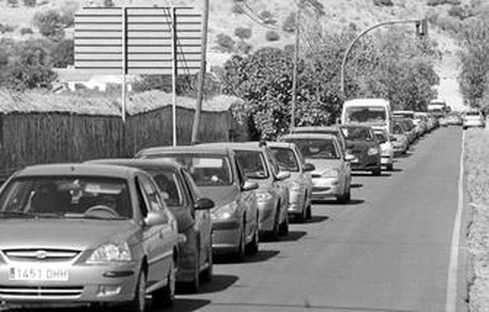 Una caravana de vehículos en el acceso al yacimiento arqueológico.