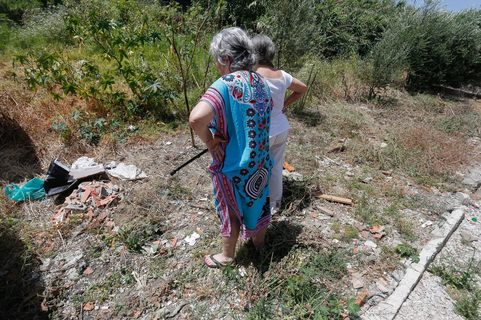 Unas vecinas de La Perlita mostrando los escombros y suciedad en el descampado.