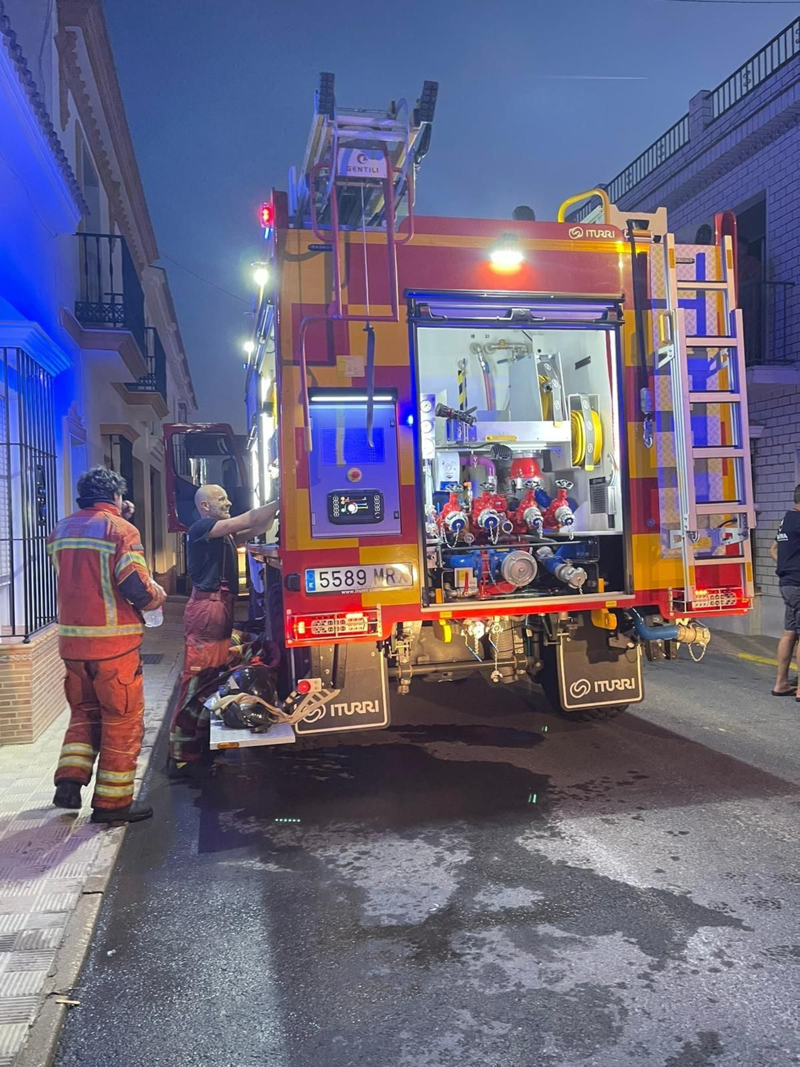 Bomberos actuando en el incendio de una casa en Moguer.