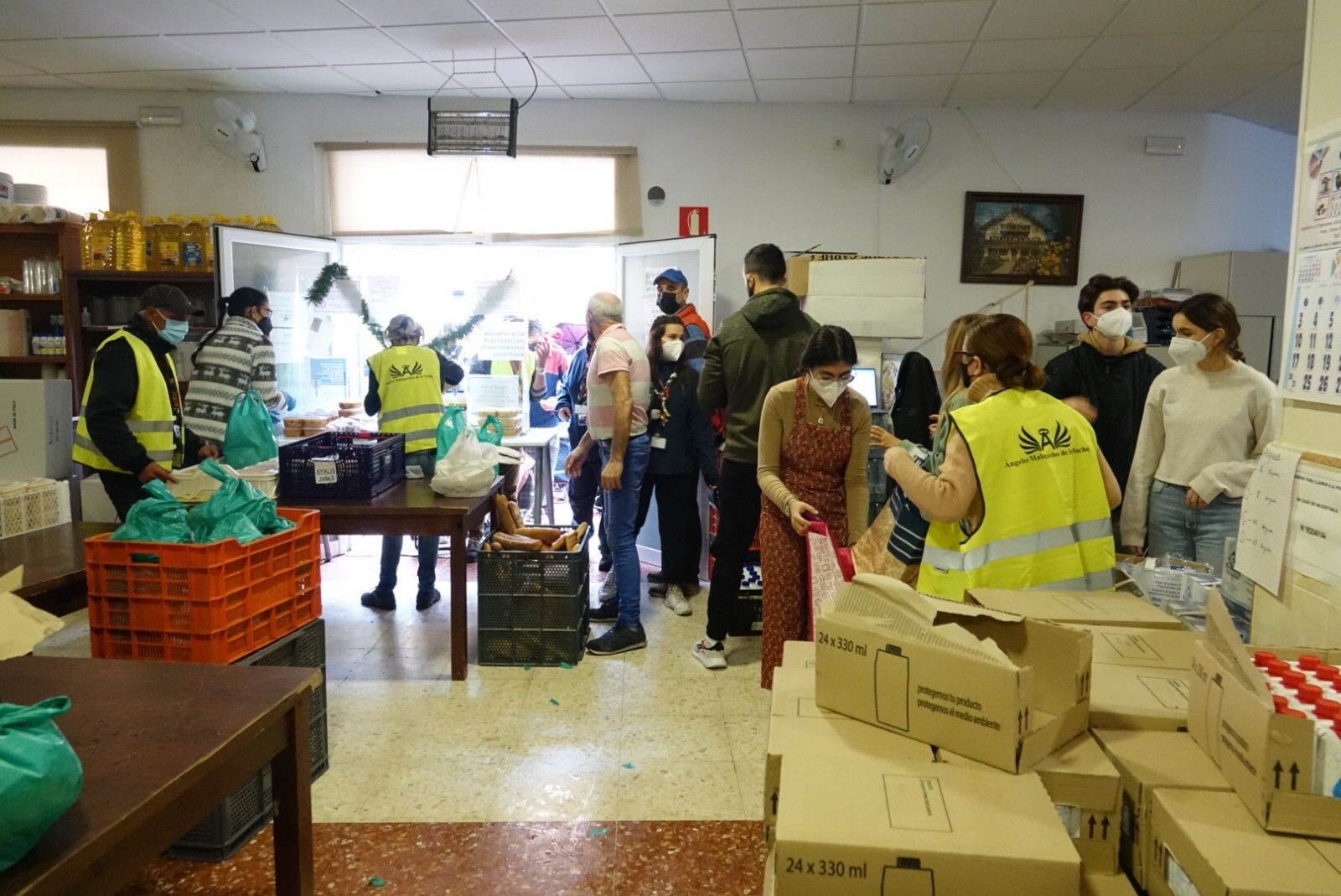 Voluntarios preparan los menús de Nochebuena para repartirlos.