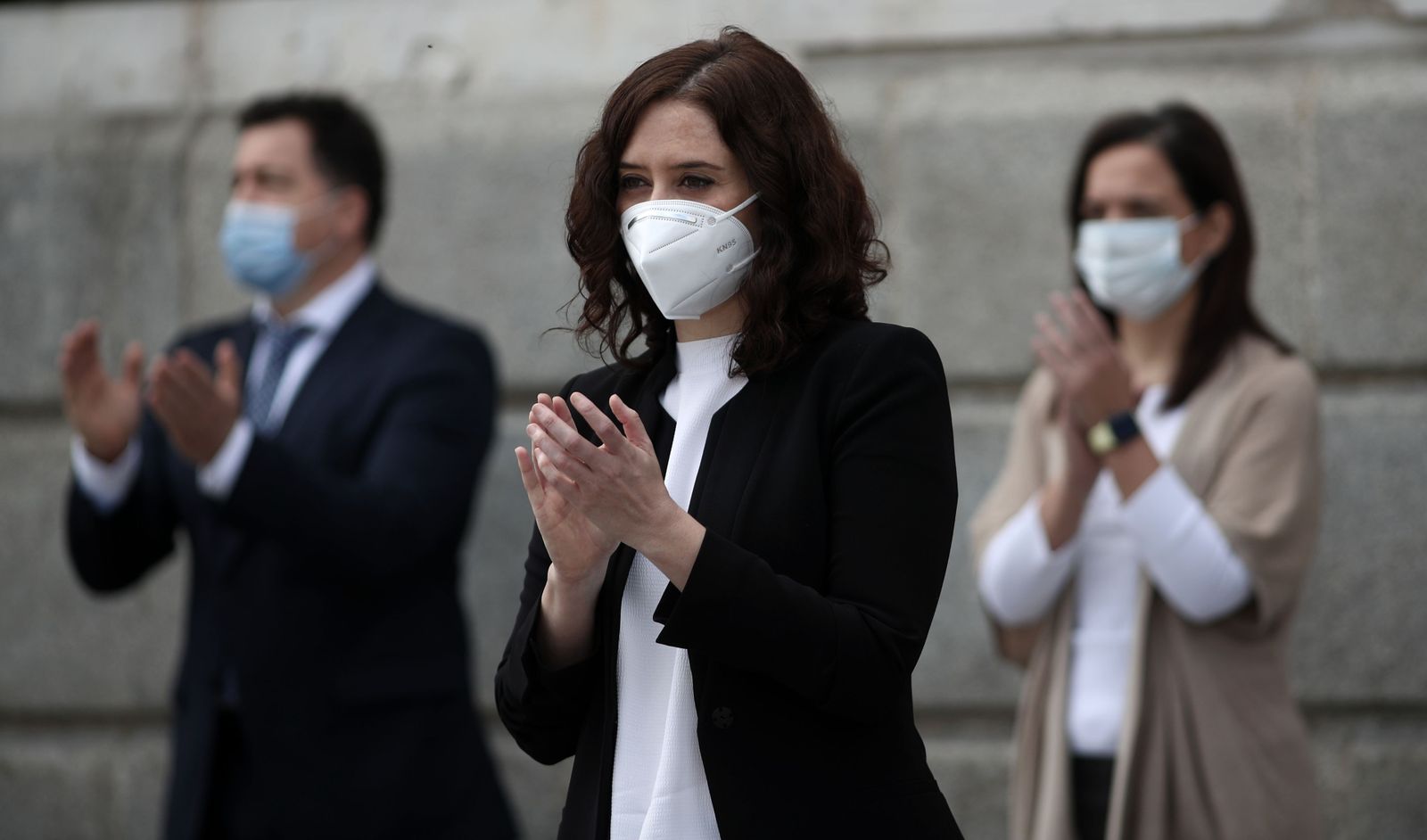 La presidenta de la Comunidad de Madrid, Isabel Díaz Ayuso, aplaude tras guardar este lunes un minuto de silencio por las víctimas de la Covid-19.