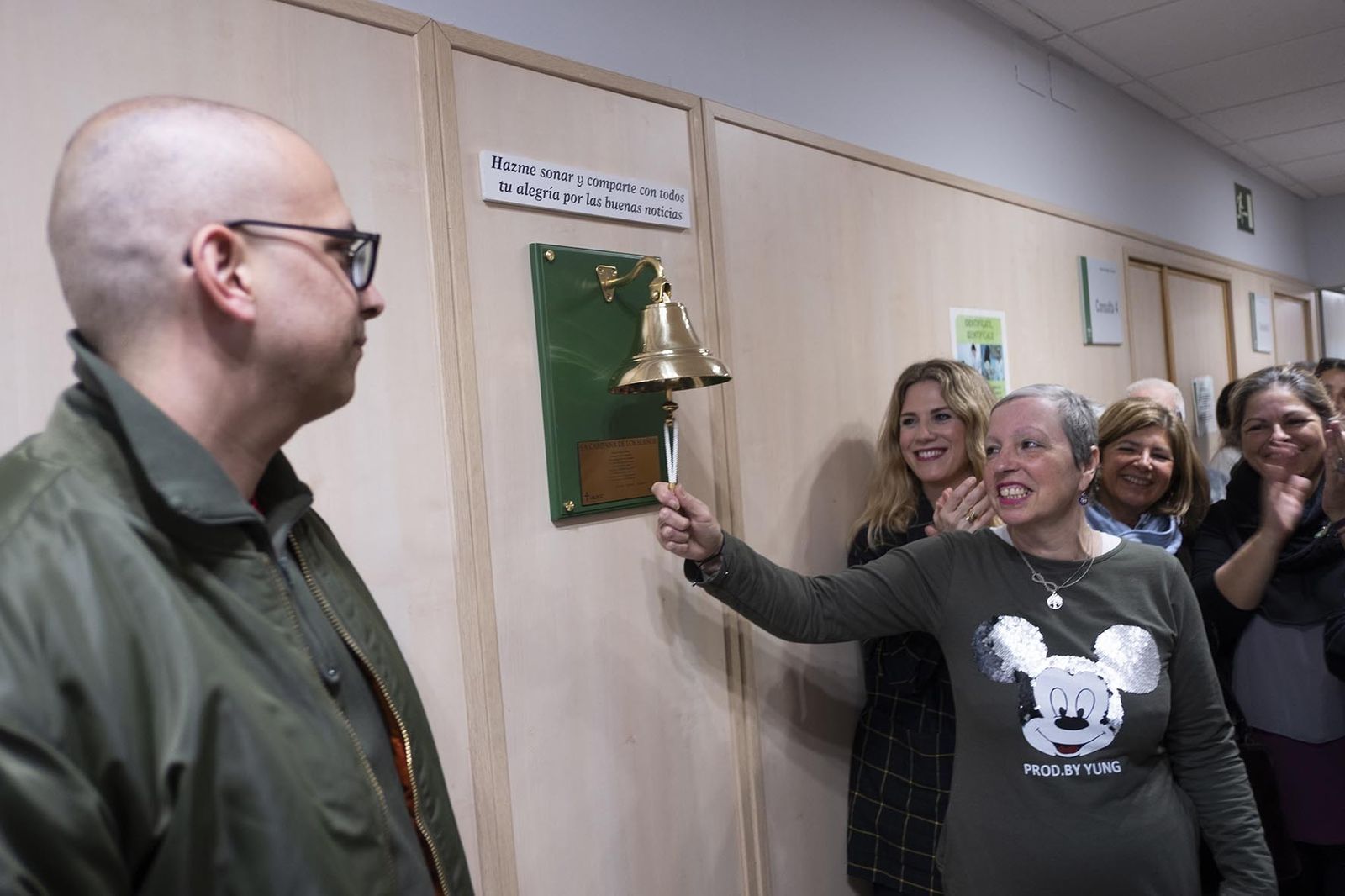 Ana tocando con satisfacción la Campana de los Sueños ante la mirada de Álvaro (en primer plano), que también la hizo sonar para anunciar su curación.