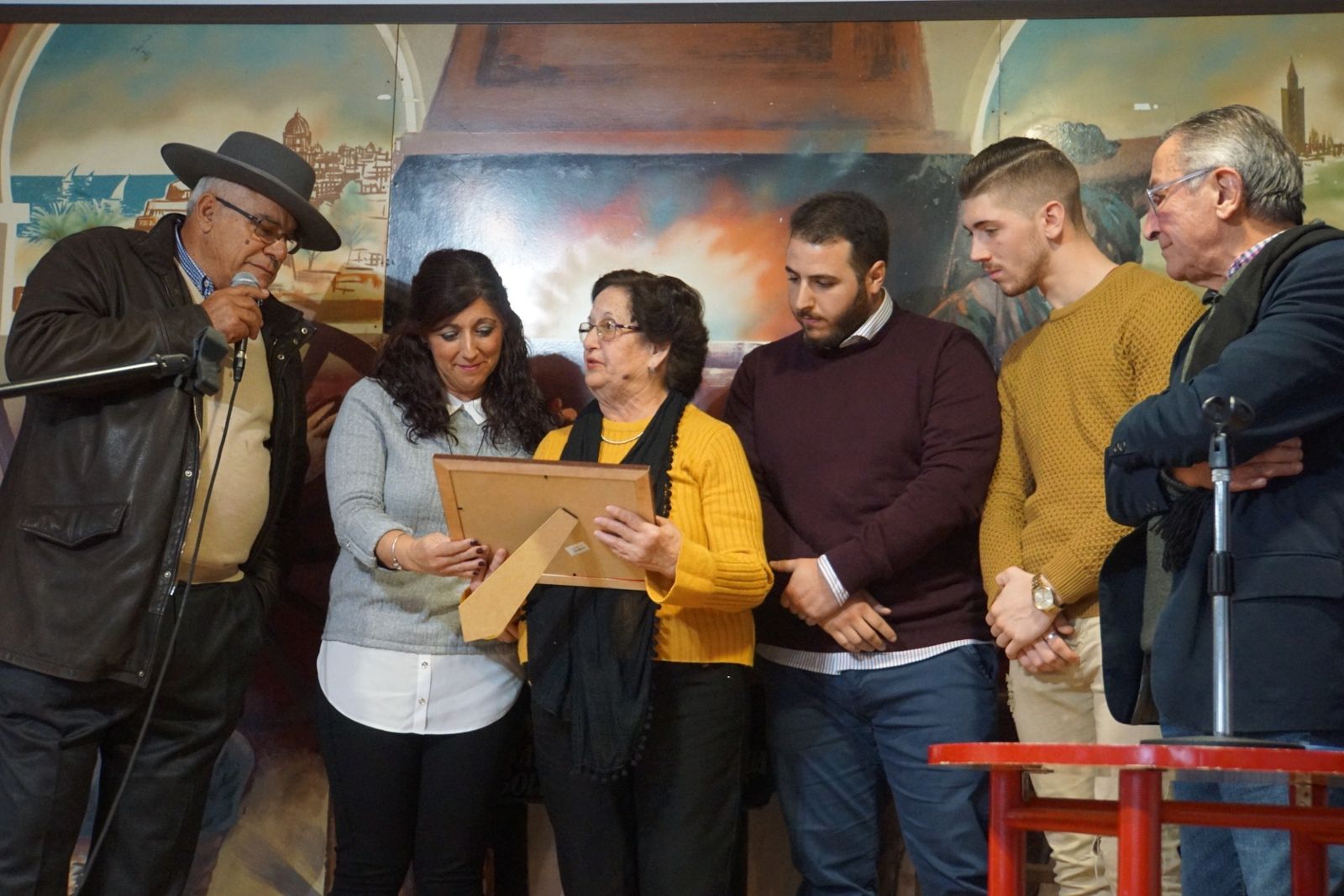 La familia de Rafael Heredia entre el presidente de la Peña Flamenca Sanroqueña, con micro, y Juan Macías.