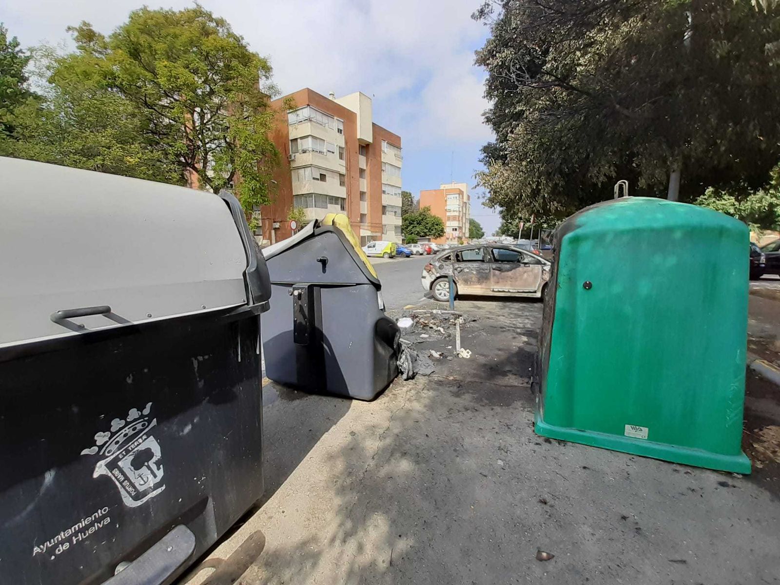 Al fondo el vehículo afectado por las llamas en la calle Artesanos, en el barrio de Santa Marta.