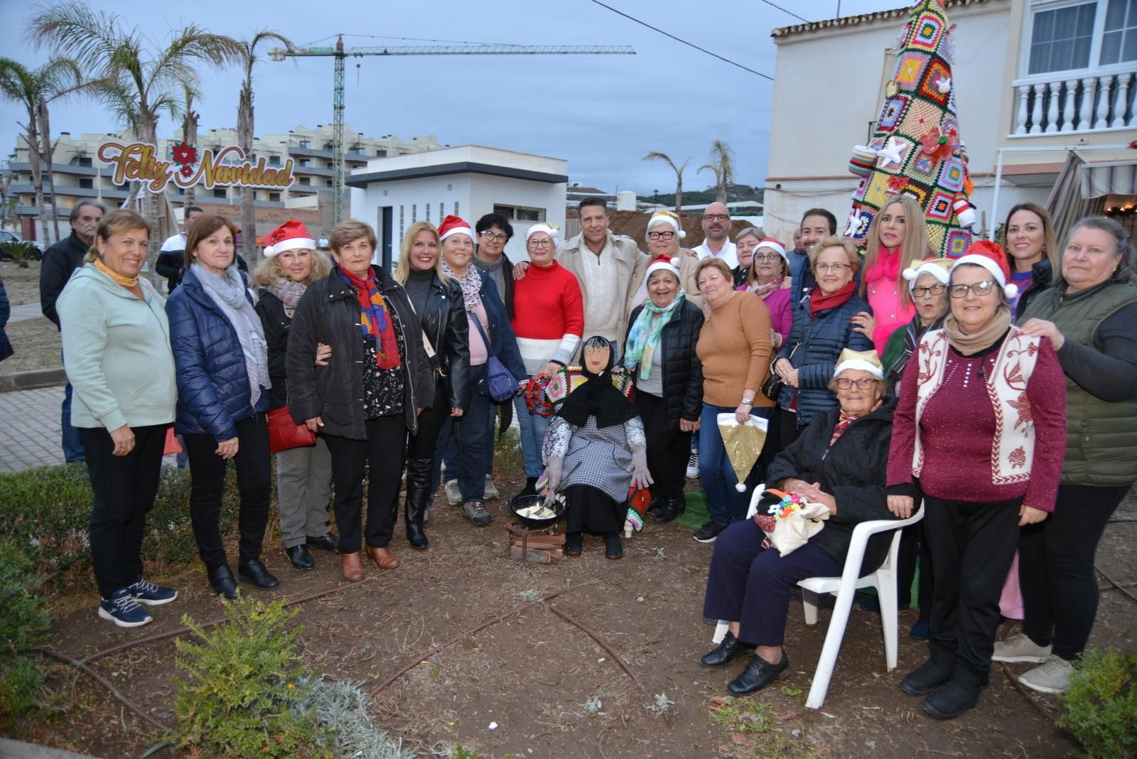 La Asociación de Mujeres La Carraca y autoridades municipales junto al árbol de Navidad de croché