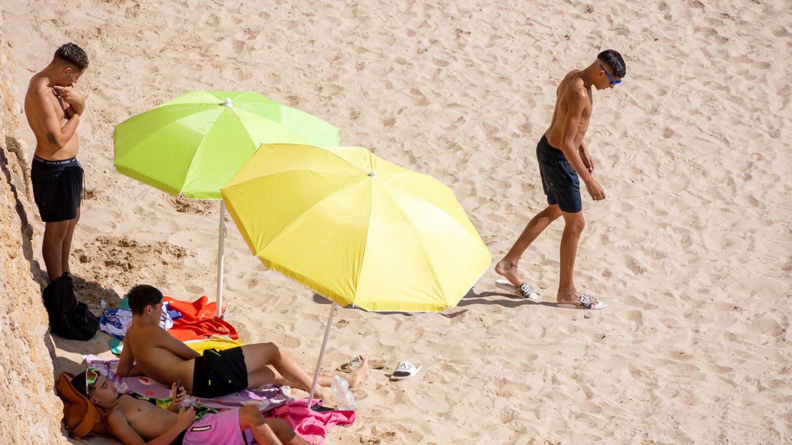 Jóvenes tomando el sol en la playa Santa María del Mar de Cádiz.