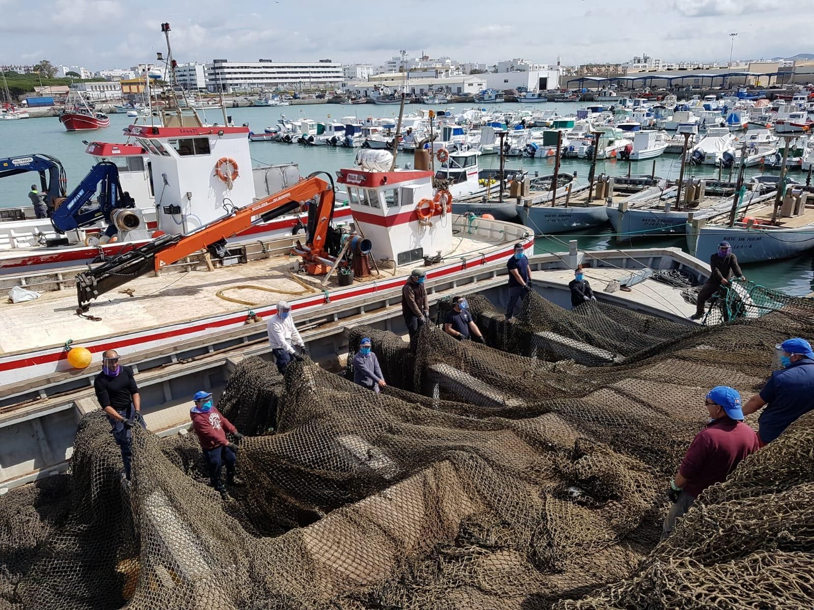 Almadraberos preparando las redes con mascarillas y pantallas protectoras ayer mismo en el puerto de Barbate.