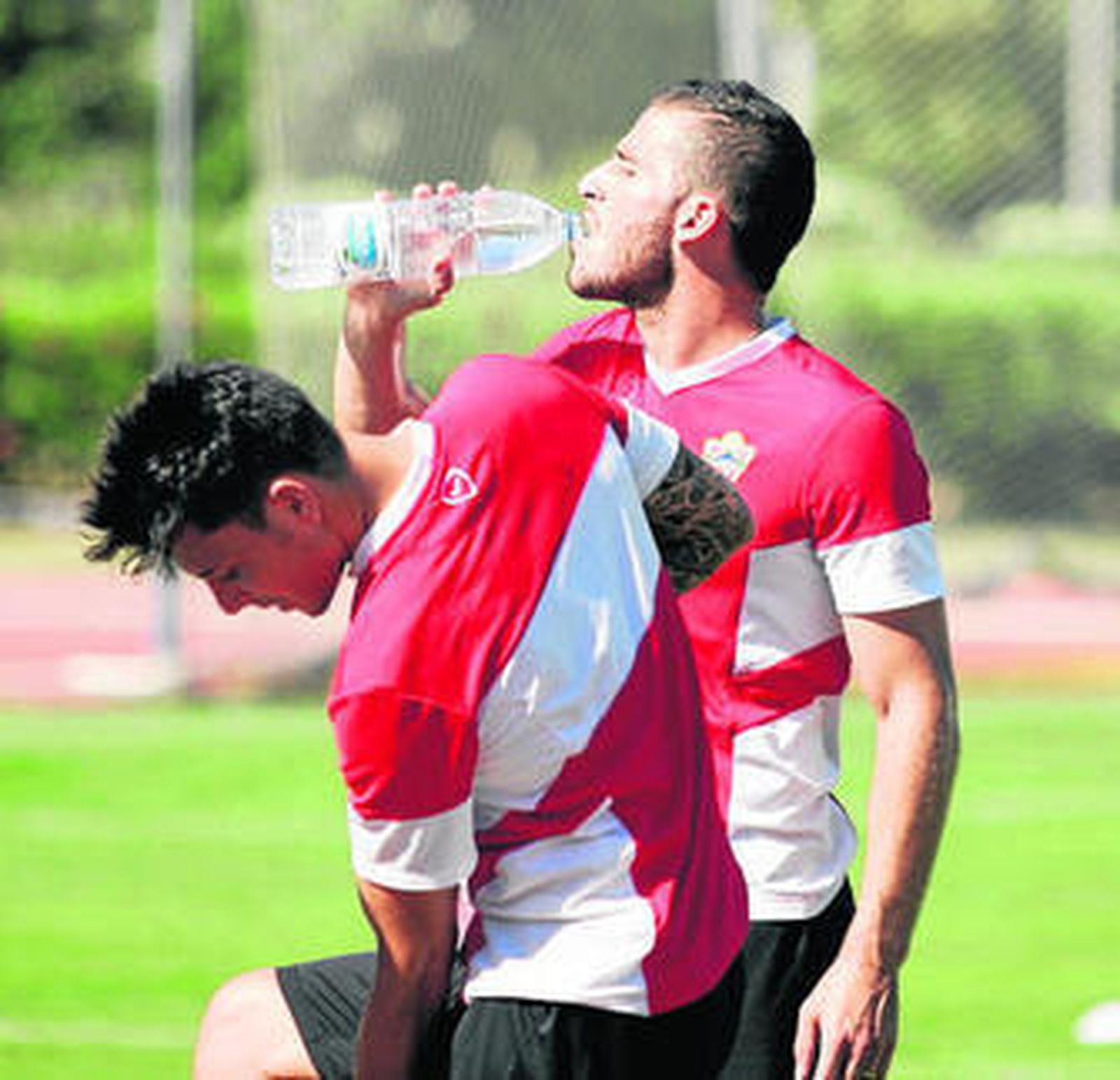 Tomer Hemed bebe agua detrás de Ximo Navarro.