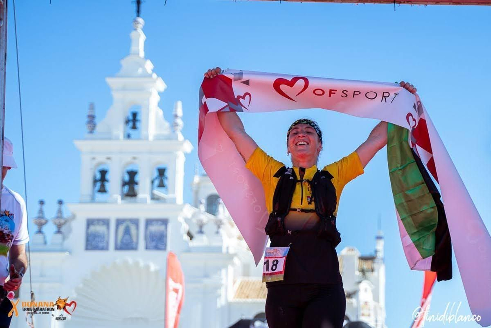 Participante cruzando la meta del Doñana Trail Marathon en El Rocío.