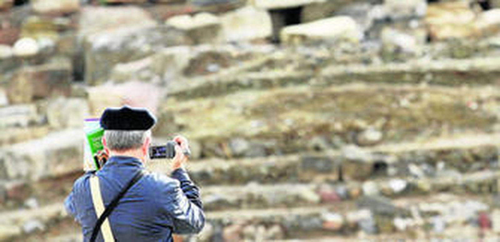 Un turista graba en el Teatro Romano de Málaga.