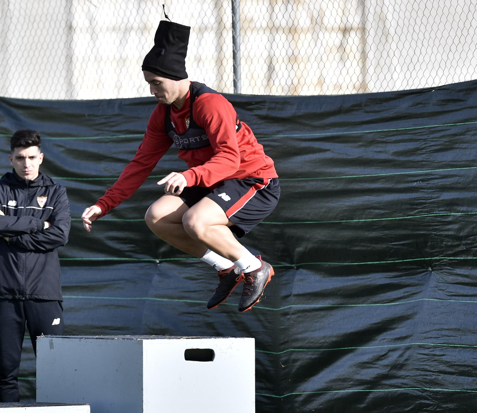 Nasri realiza un salto durante un circuito de ejercicios ante un utillero del Sevilla.