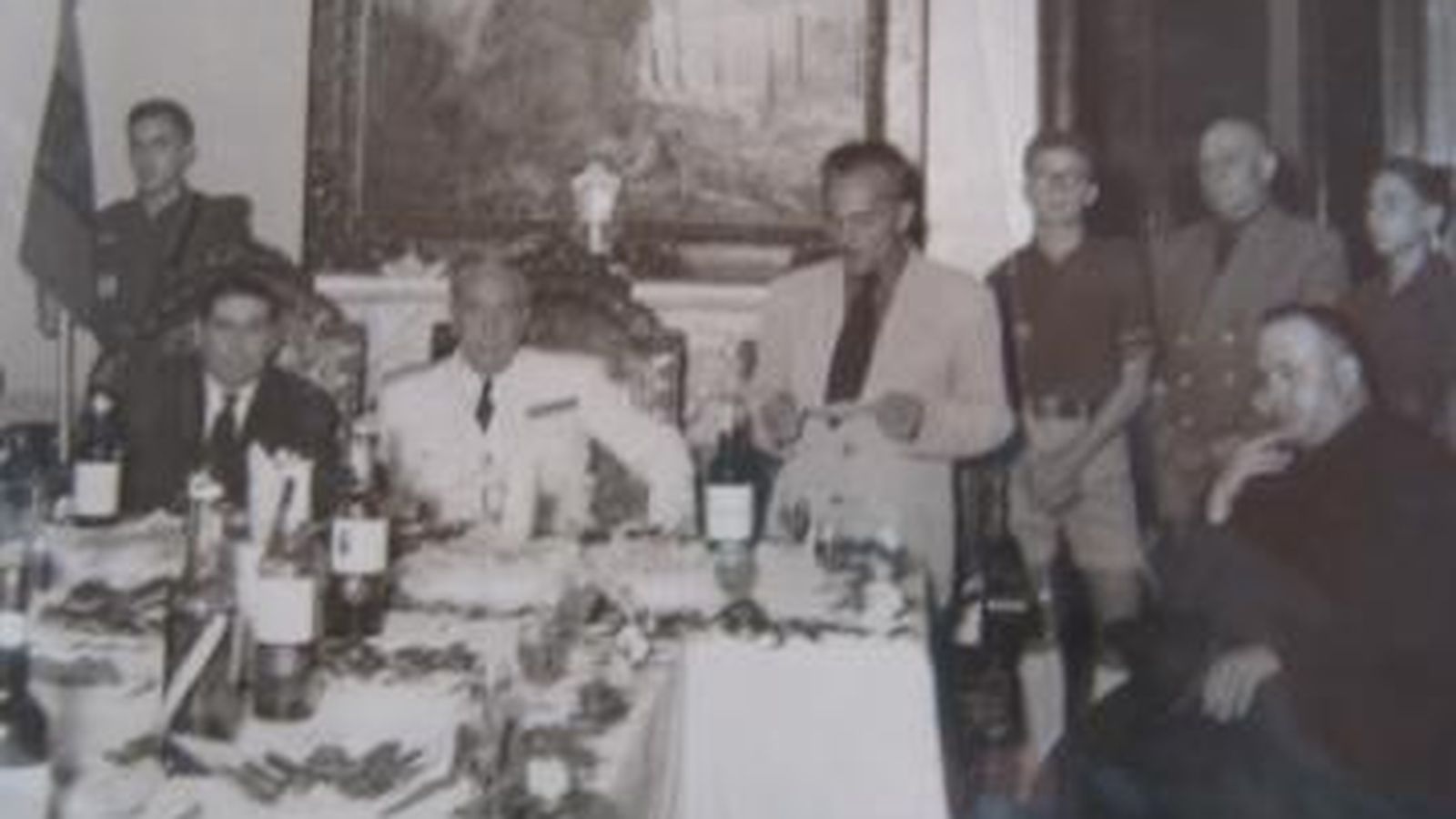 Ernesto de Casas leyendo un escrito. Detrás de él, su hijo Ernesto