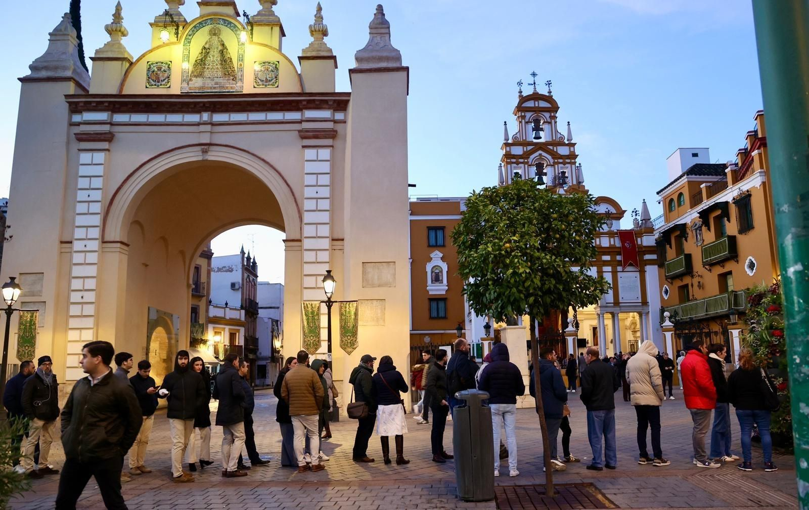 La larga cola de devotos de la Macarena, a su paso por las puertas de la Basílica al amanecer.