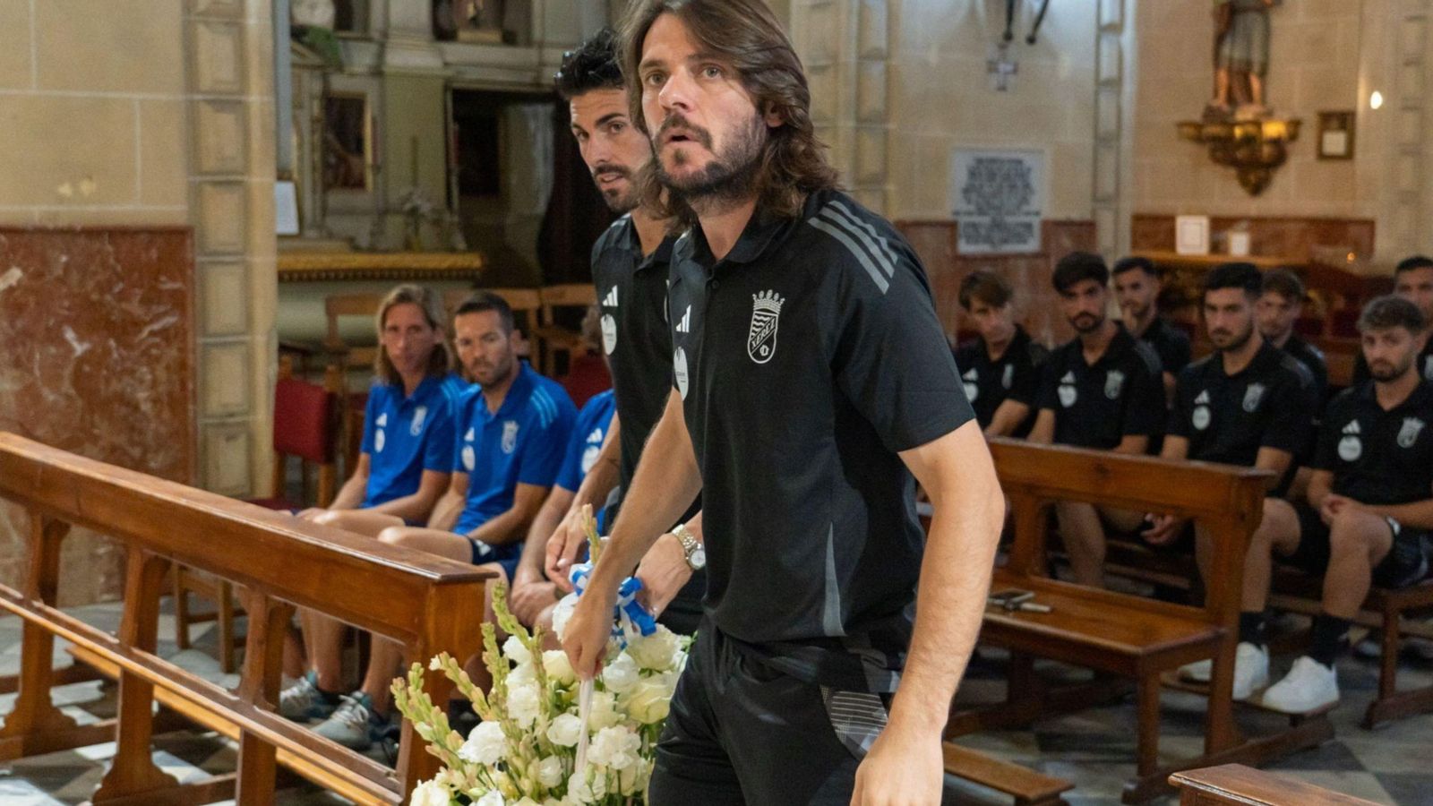 Los capitanes azulinos Isma Gil y Migue García portan un centro de flores para la Virgen.