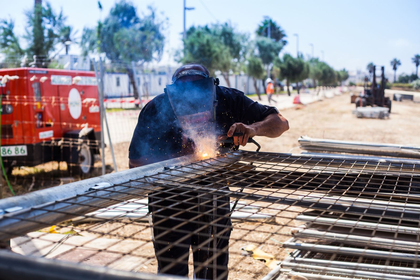 Un soldador trabaja en la instalación de un escenario en la provincia.