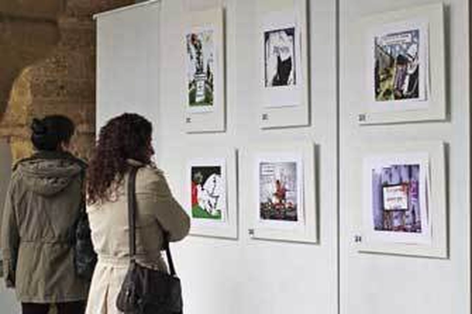 Dos jóvenes observan las obras de la exposición Pazlestina en la Facultad de Filosofía y Letras. /Lourdes de Vicente