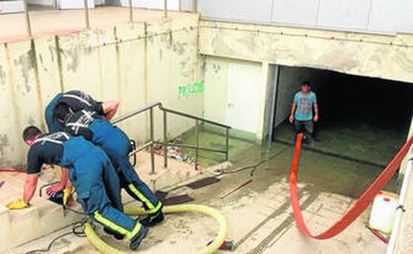 Bomberos achican el agua que ha inundado el sótano de la instalación municipal.