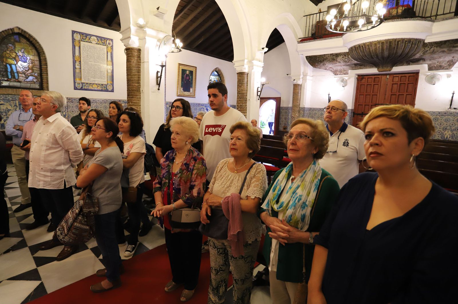 Los participantes de la visita guiada por el santuario de La Cinta atienden las explicaciones sobre el altar.