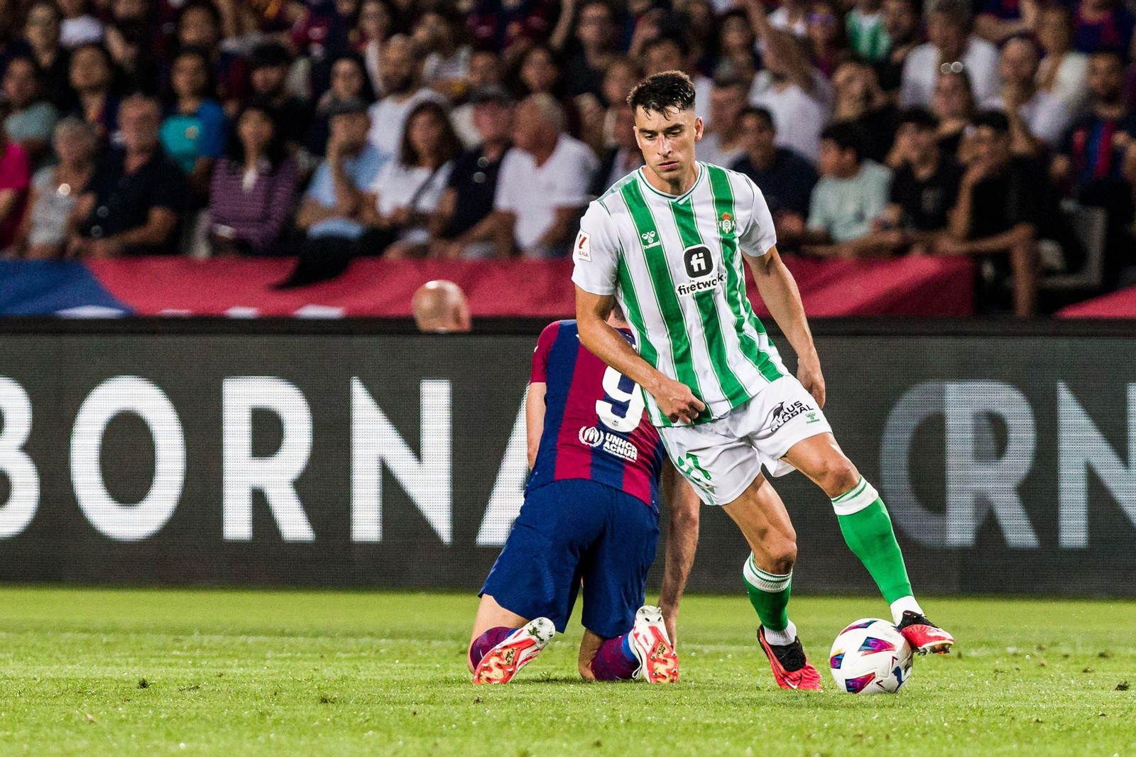 Marc Roca se lleva la pelota tras robársela a Lewandowski en un lance del encuentro disputado en Montjuic.