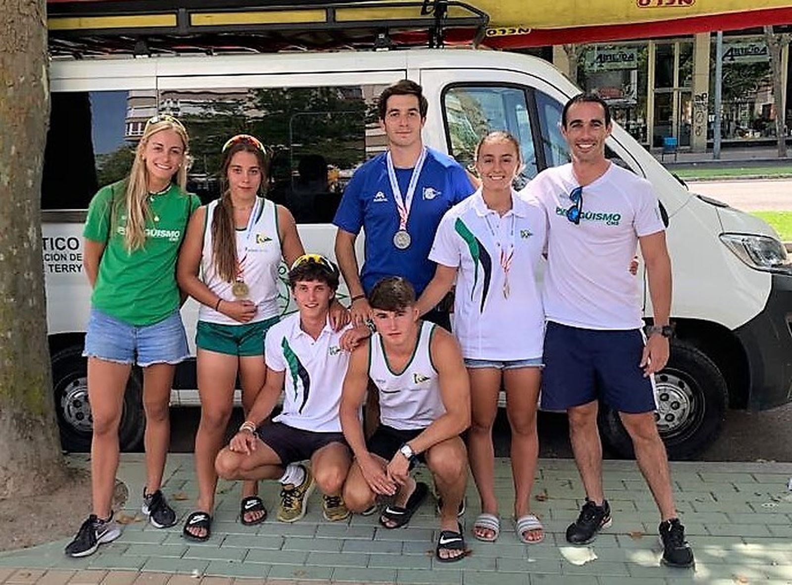 Los palistas del Club Náutico Sevilla posando con sus medallas y los demás integrantes del equipo.