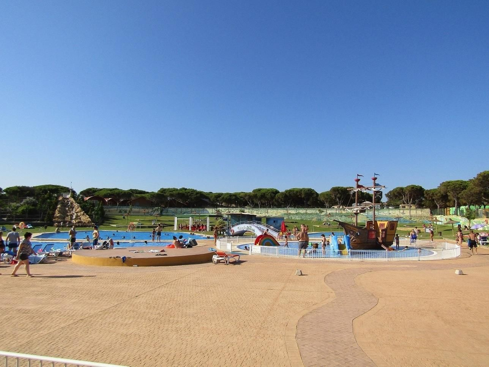 1. La piscina del camping, que incorpora juegos para los más pequeños. 2. Una familia natural de Sevilla en una de las viviendas nuevas del camping. 3. Otro grupo de campistas disfruta de la jornada estival en el bar de la piscina. 4. Parcelas para la acampada que resultaron arrasadas en el incendio. 5. Una familia posa en su tienda de campaña, sita en una zona en la que los pinos no resultaron afectados por las llamas. 6. Familiares y amigos en una cabaña. 1. La piscina del camping, que incorpora juegos para los más pequeños. 2. Una familia natural de Sevilla en una de las viviendas nuevas del camping. 3. Otro grupo de campistas disfruta de la jornada estival en el bar de la piscina. 4. Parcelas para la acampada que resultaron arrasadas en el incendio. 5. Una familia posa en su tienda de campaña, sita en una zona en la que los pinos no resultaron afectados por las llamas. 6. Familiares y amigos en una cabaña.