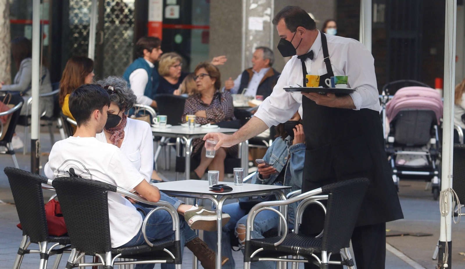 Un camarero atiende a unos clientes.