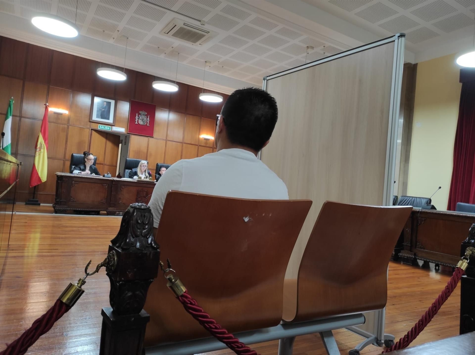 El acusado escucha a su sobrina, que ha declarado separada por un biombo.