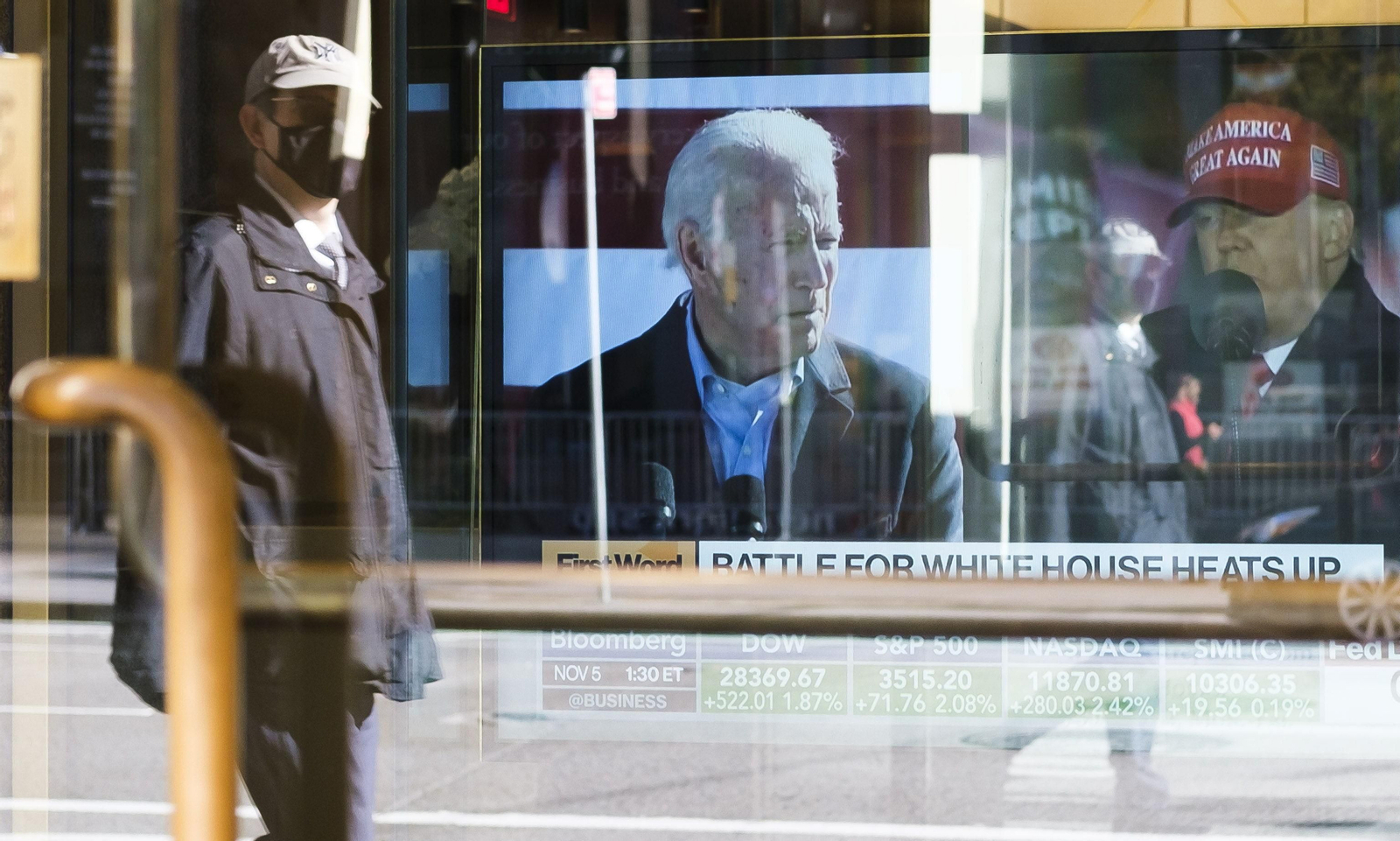 Un hombre pasa ante una pantalla con los dos candidatos a la Presidencia de EEUU