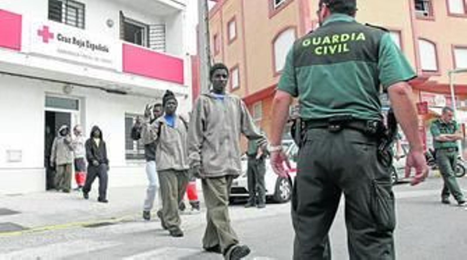 Varios inmigrantes cruzan la calle tras salir de la asamblea local de Cruz Roja de Tarifa, ayer.