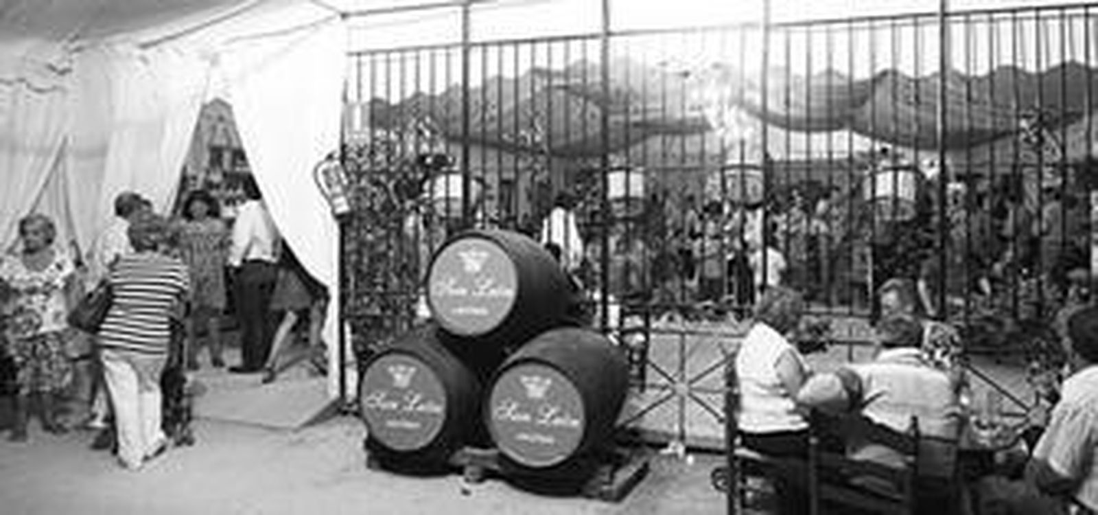 Entrada de la caseta La Trabajadera y al fondo, socios y amigos disfrutando de una noche de feria.