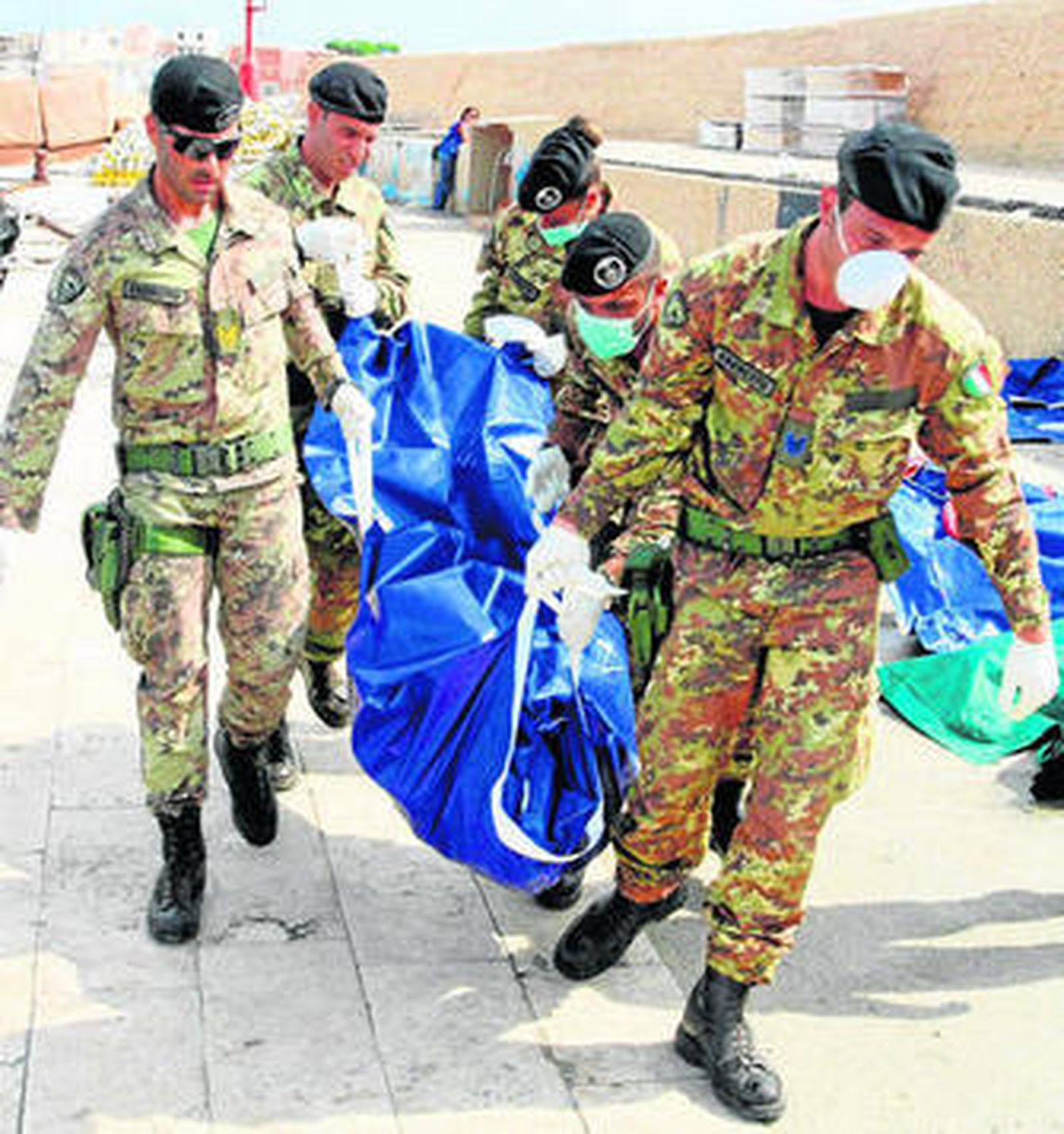 Soldados italianos con una de las víctimas del naufragio de la semana pasada.