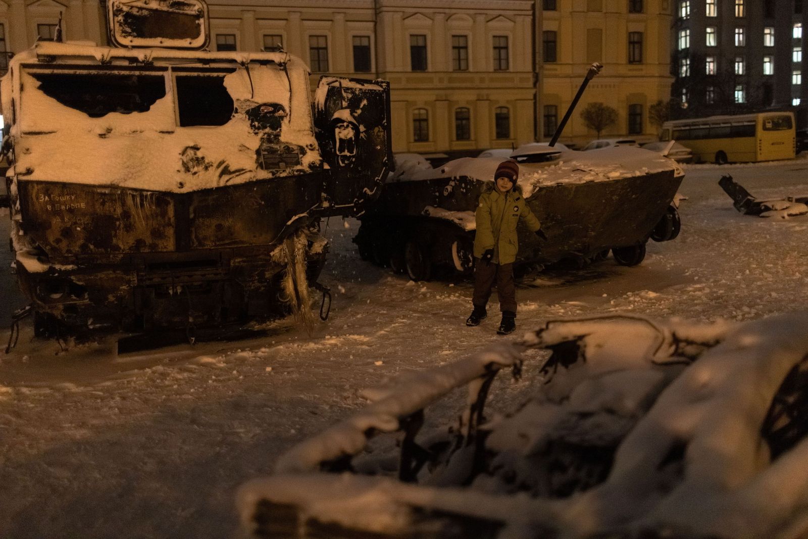 Un niño juega con la nieve junto a unos vehículos militares rusos destruidos en Kiev.