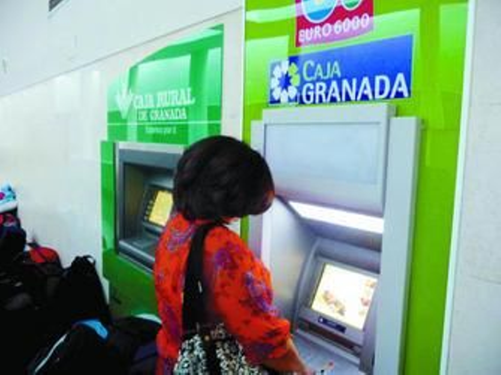 Una mujer saca dinero del cajero de la estación de autobuses, uno de los que se verá afectado por la subida.