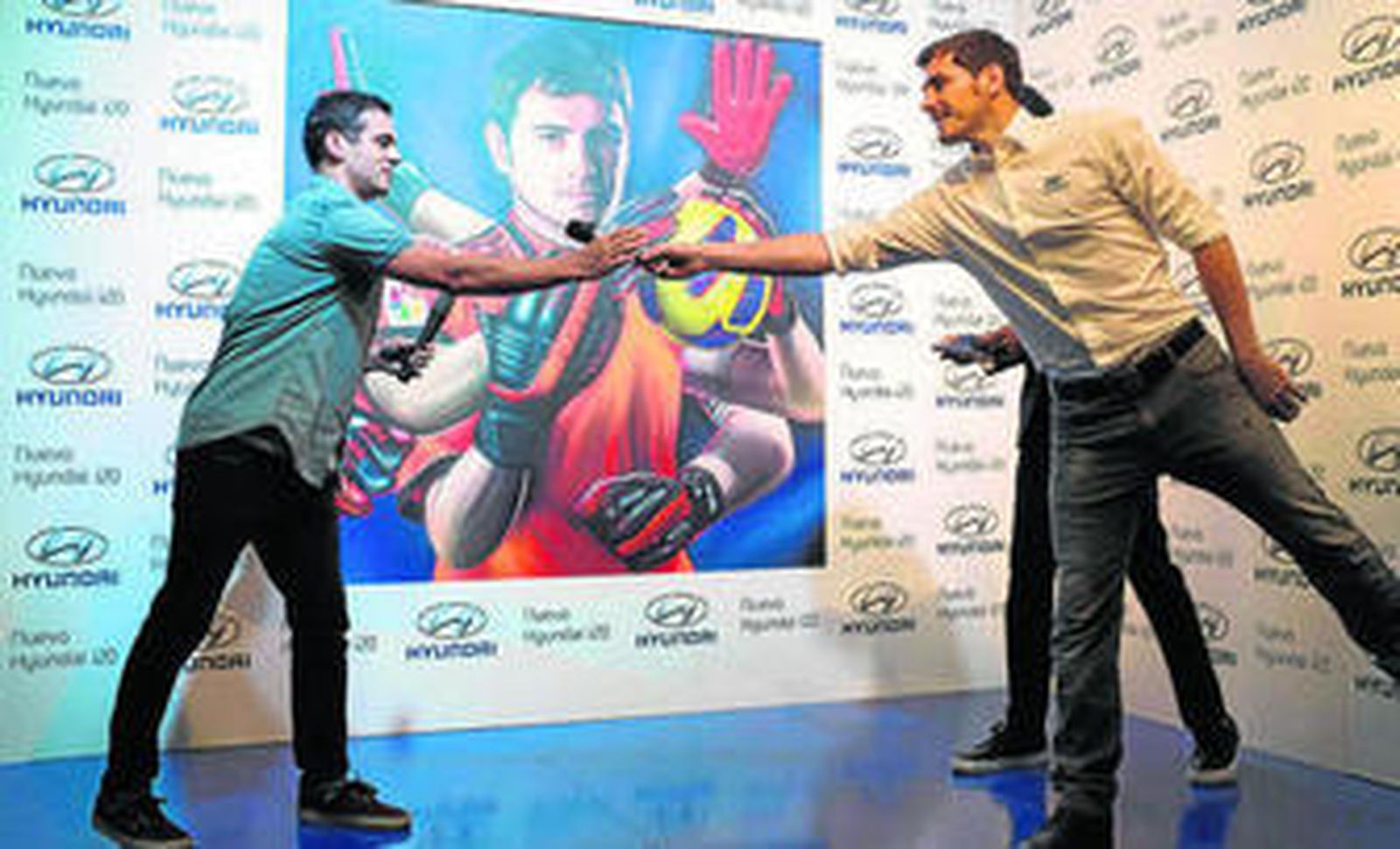 Iker Casillas saluda al grafitero Spok, autor de su retrato, en un acto publicitario.