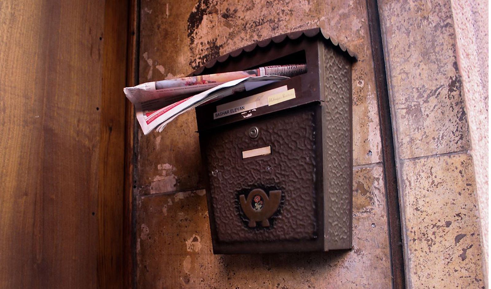 Folletos de publicidad sobresalen de un buzón en una vivienda.