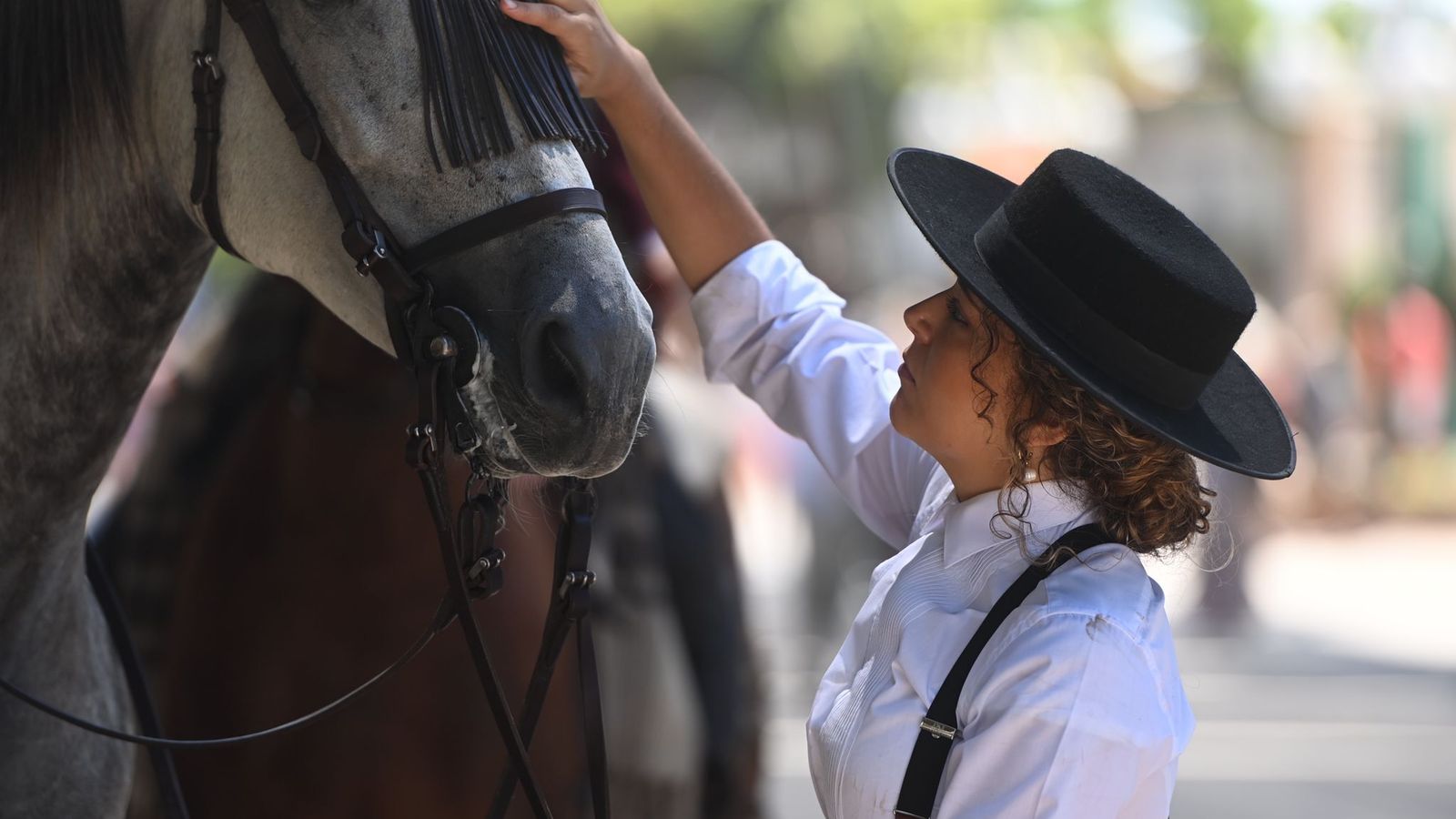 Una jinete acaricia a su caballo este jueves en el Real de la Feria de Málaga.