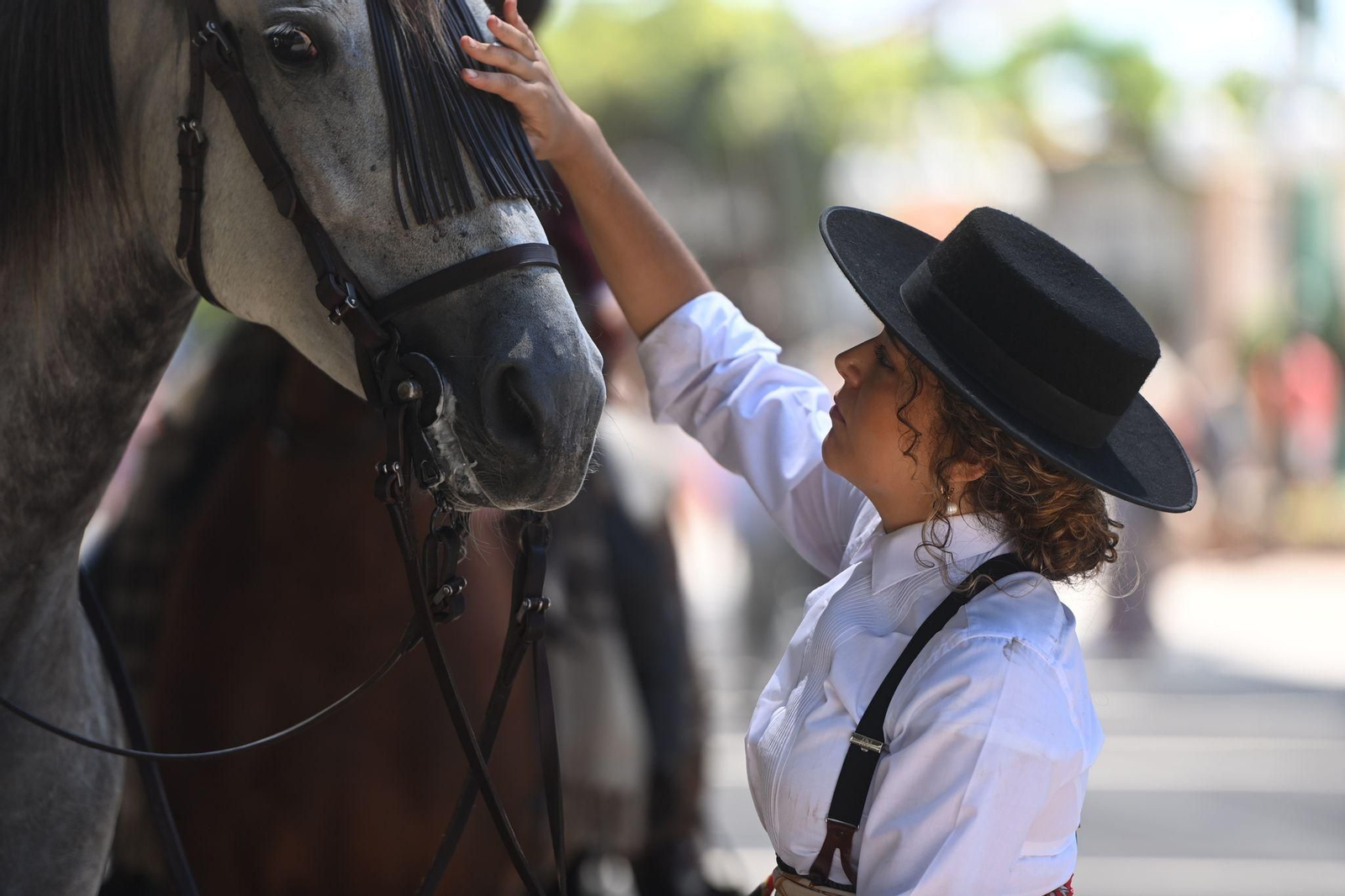 Una jinete acaricia a su caballo este jueves en el Real de la Feria de Málaga.