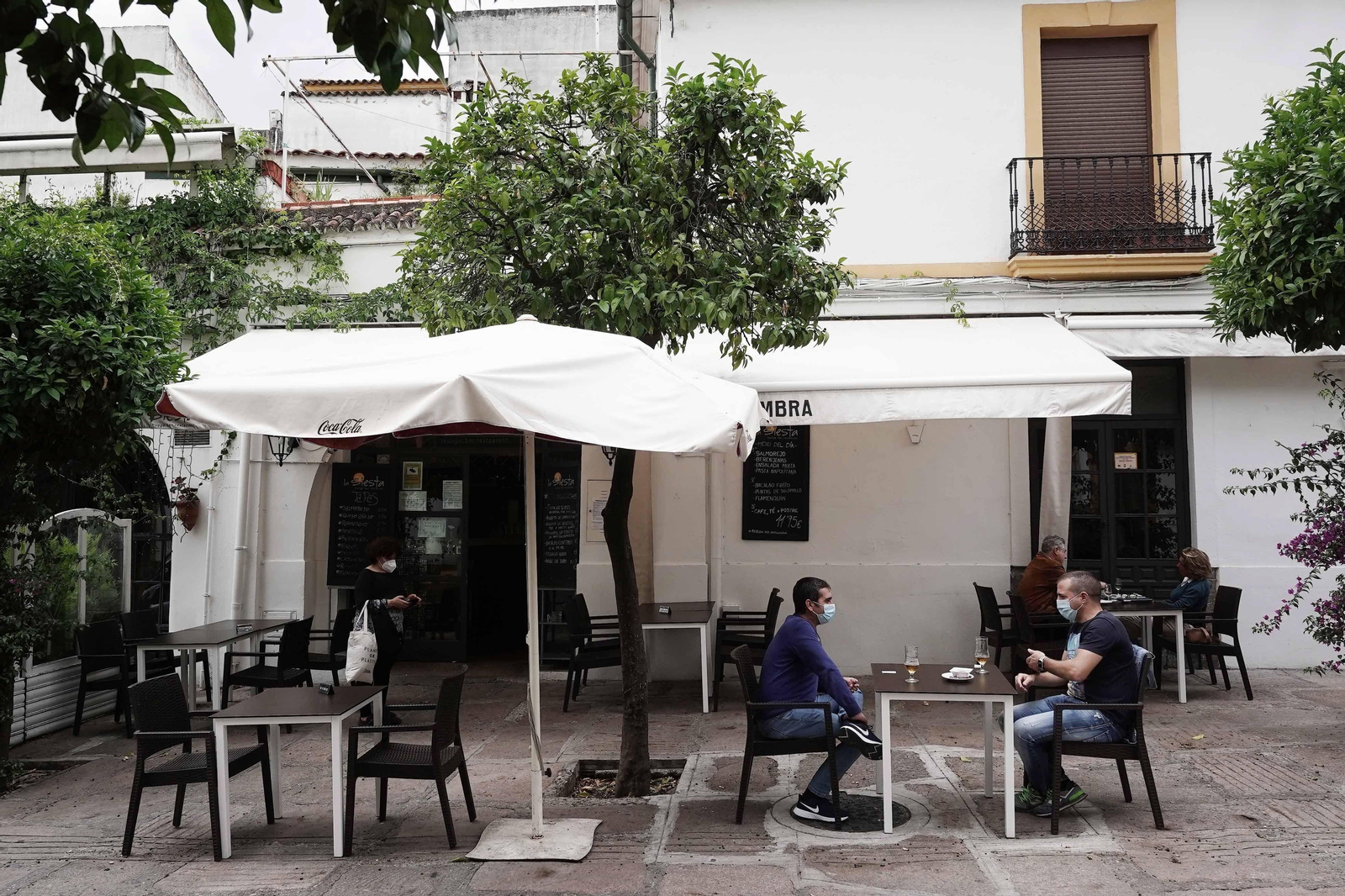 Varias personas toman algo en un restaurante cercano a la Ribera.