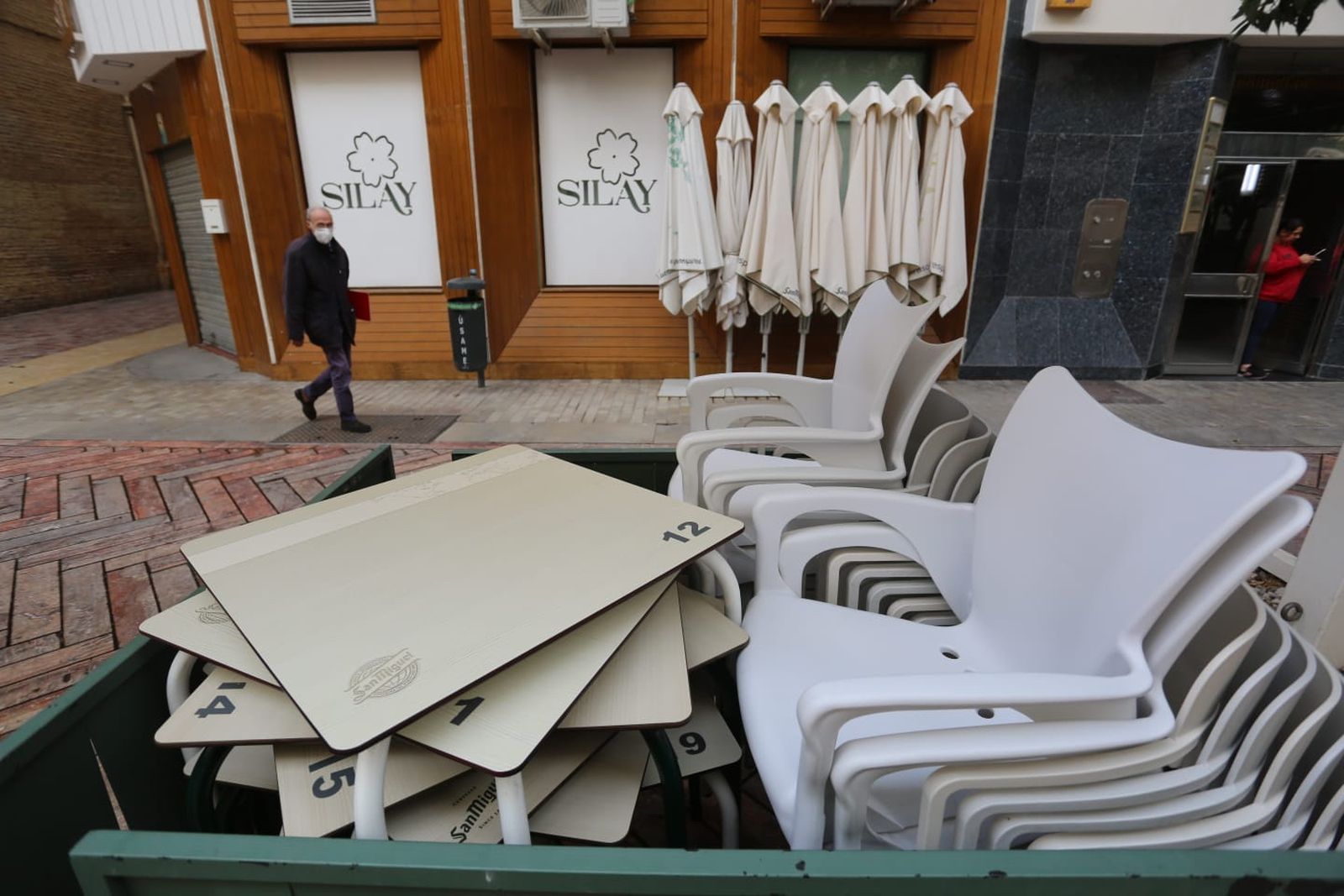Mesa y sillas de la terraza de un bar de la Plaza de las Flores, cerrado.