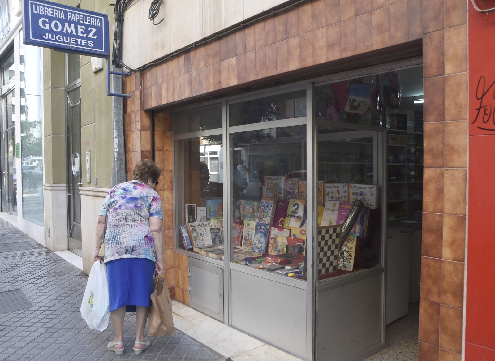 Una mujer mira el escaparate de una tienda.