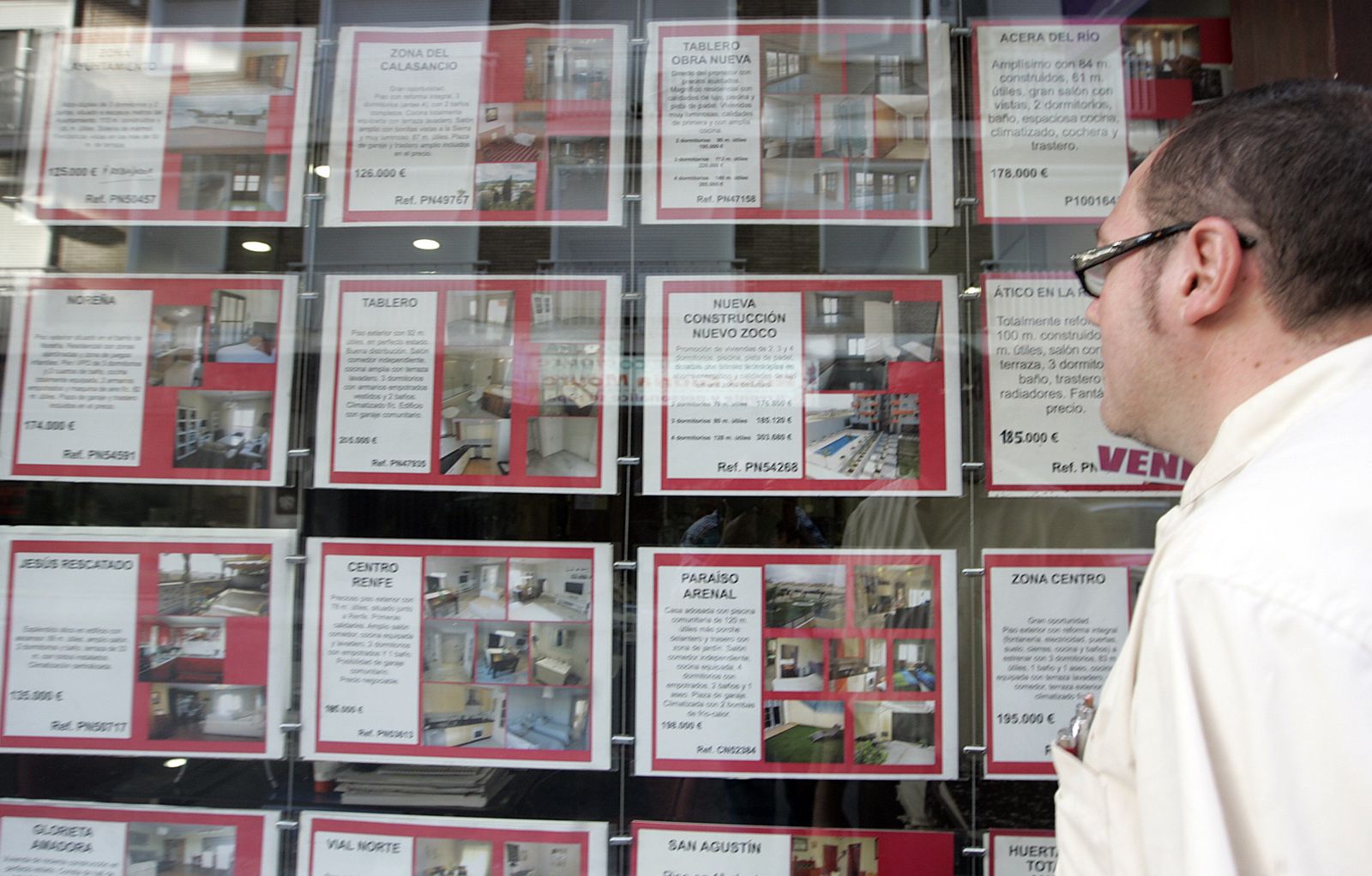 Un hombre consulta los carteles de una inmobiliaria.