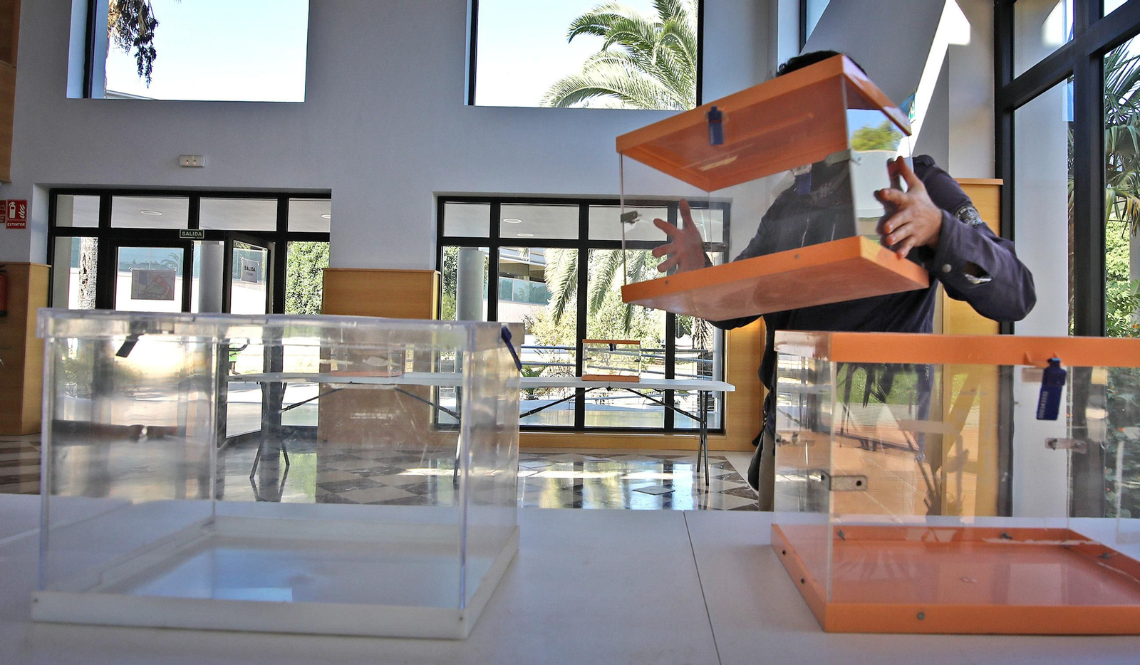 Un operario municipal colocando las urnas en el edificio Jerez 2002, en el complejo deportivo de Chapín.