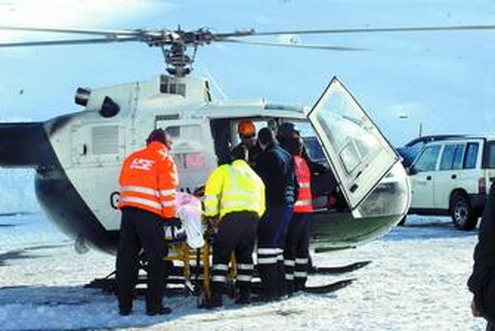 Efectivos sanitarios trasladan a una UVI móvil a uno de los fallecidos.