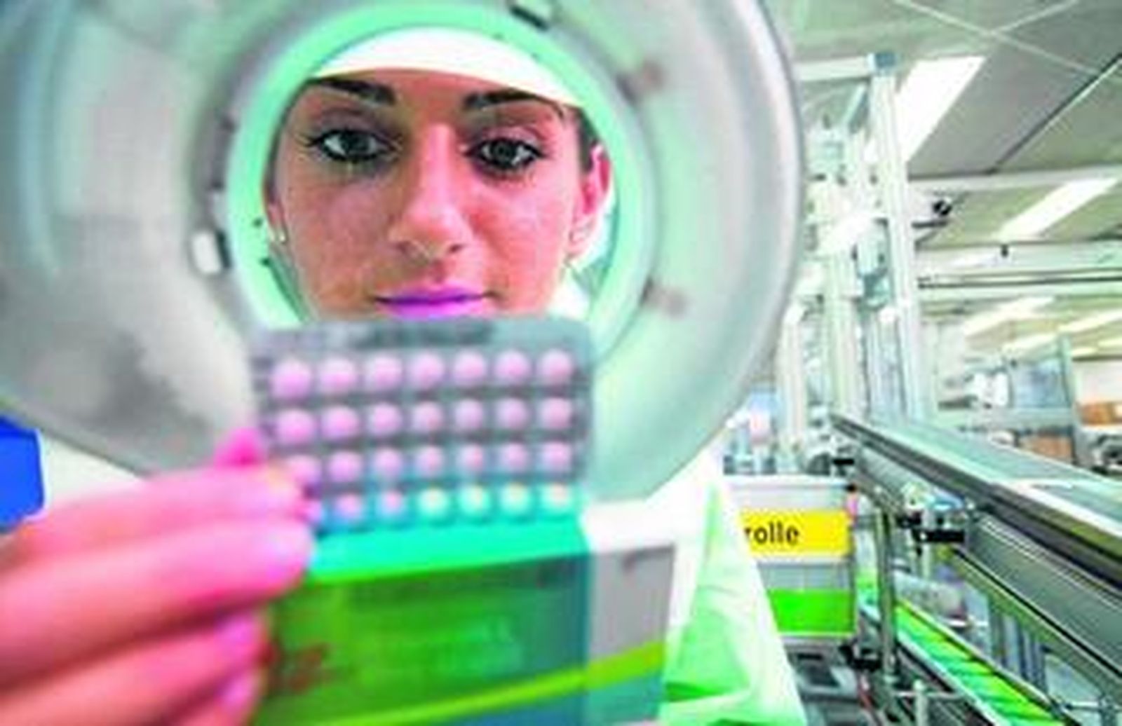 Una empleada inspecciona una tableta de píldoras en el centro de producción de Bayer Schering en Berlín.