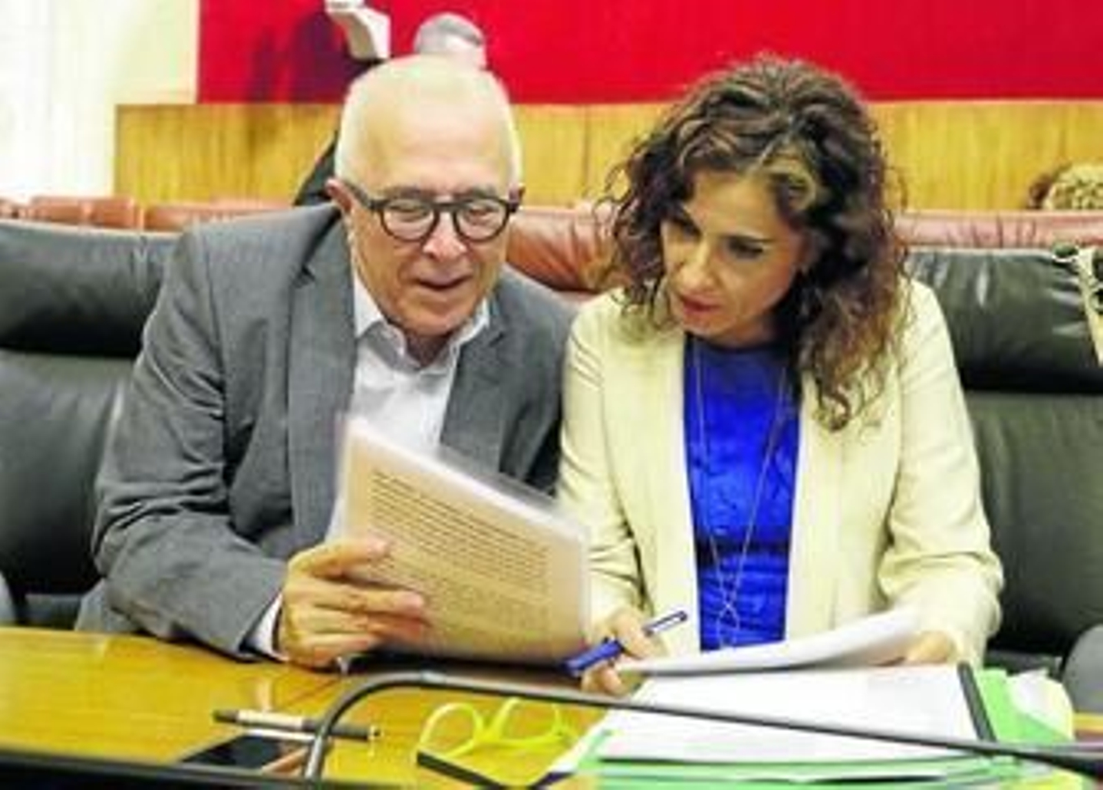 José Sánchez Maldonado, consejero de Empleo, Empresa y Comercio, muestra unos papeles a María Jesús Montero, consejera de Hacienda, en una sesión plenaria.