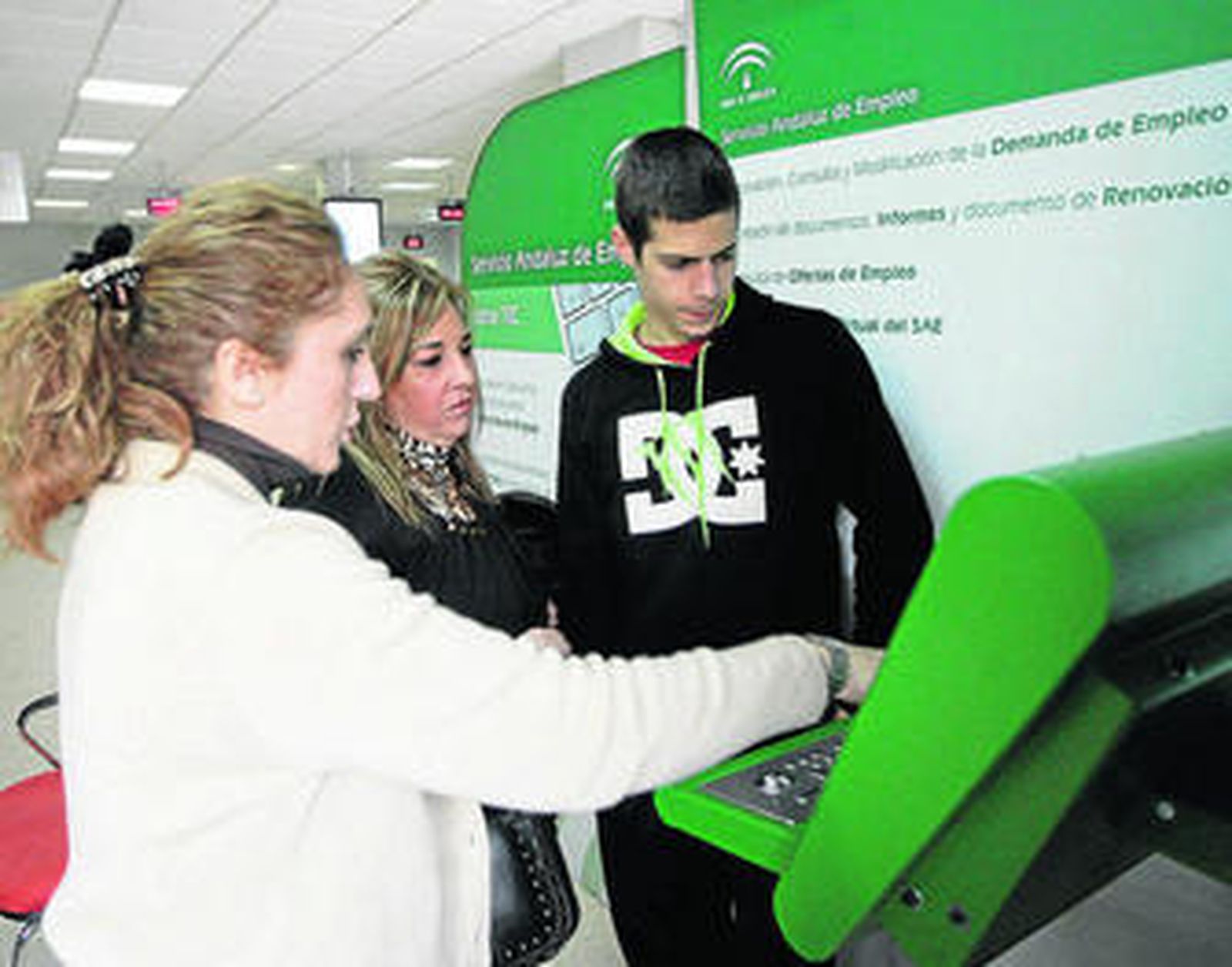 Una empleada enseña a un usuario a utilizar un nuevo sistema para demandar empleo.