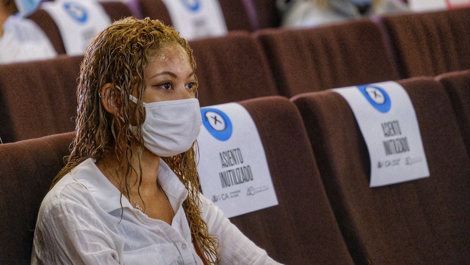 Una joven Erasmus permanece atenta, entre "asientos inutilizados" por el covid, a las explicaciones de los representantes de la UCA