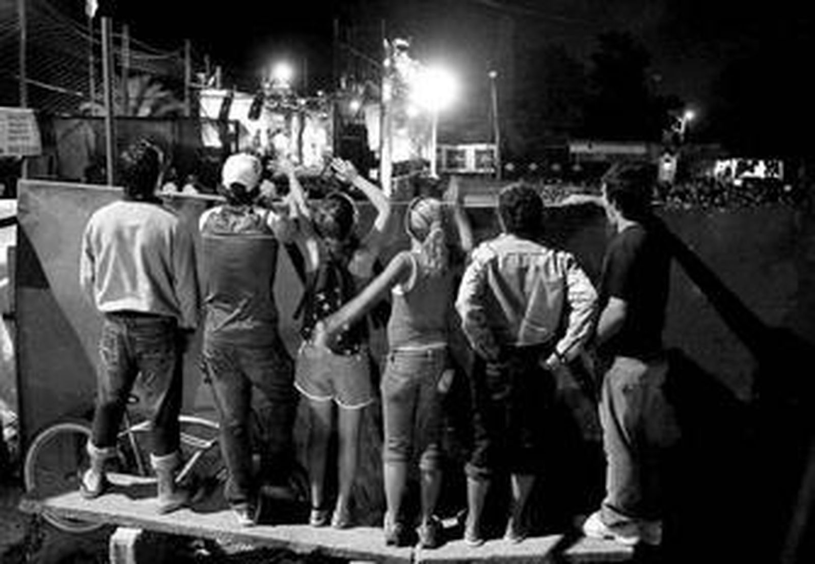 En el tablado de Lagomar, la gente que no quiere o no puede pagar se busca la vida para asistir al espectáculo en directo.