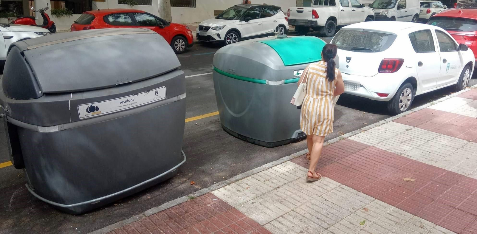 Una mujer reciclando en un contenedor de vidrio en Marbella.
